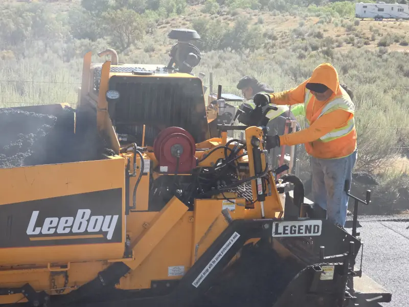 Close of a LeeBoy paver machine laying asphalt on a road in Anza, CA