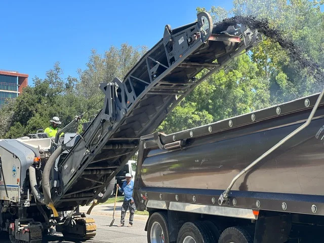 Asphalt being milled off a parking lot.